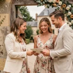 Coordinatrice de mariage accueillant des invités à l'entrée d'un château avec des programmes de cérémonie