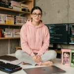 Jeune femme geek entourée de gadgets high-tech et figurines pop culture sur un bureau minimaliste